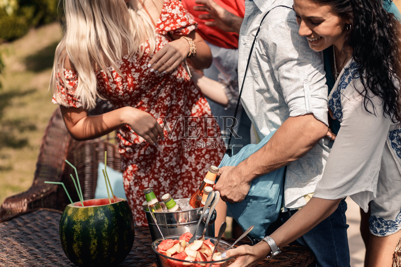 一群朋友在暑假享受在泳池边的派对。照片摄影图片