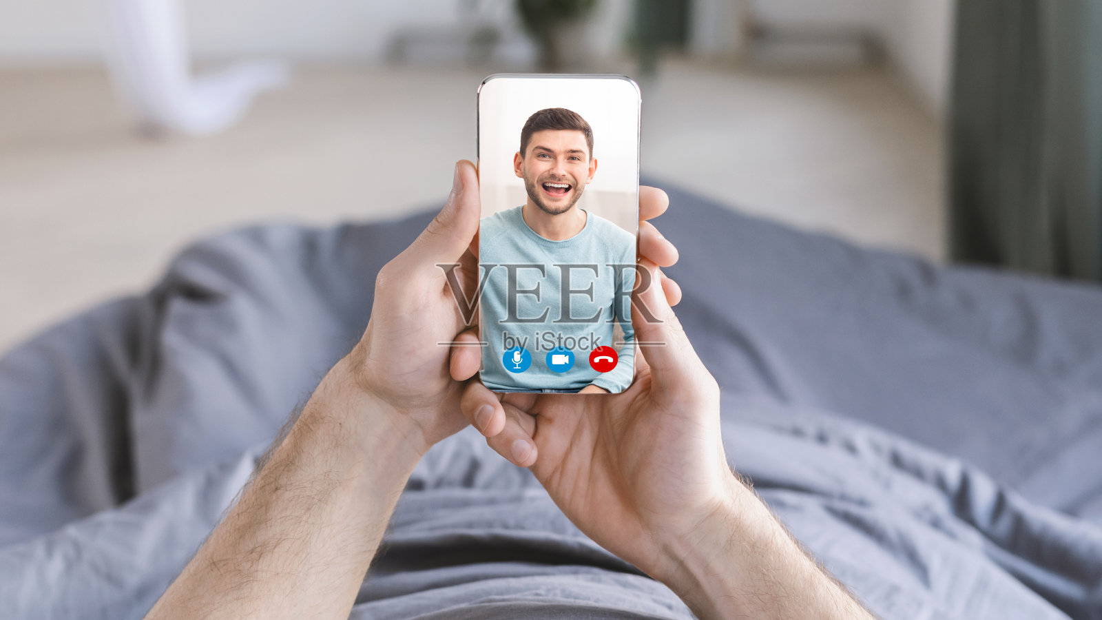 一个面目全非的男人躺在床上用手机和朋友视频聊天照片摄影图片