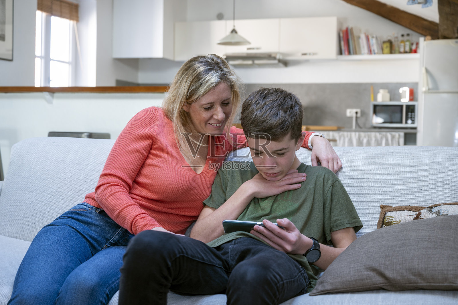 青少年在家里用手机和妈妈分享内容照片摄影图片