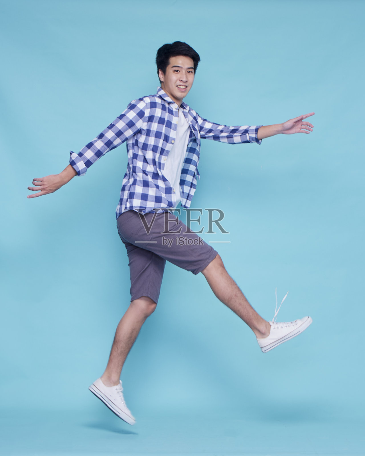 年轻人在彩色背景上跳。假期旅行照片摄影图片