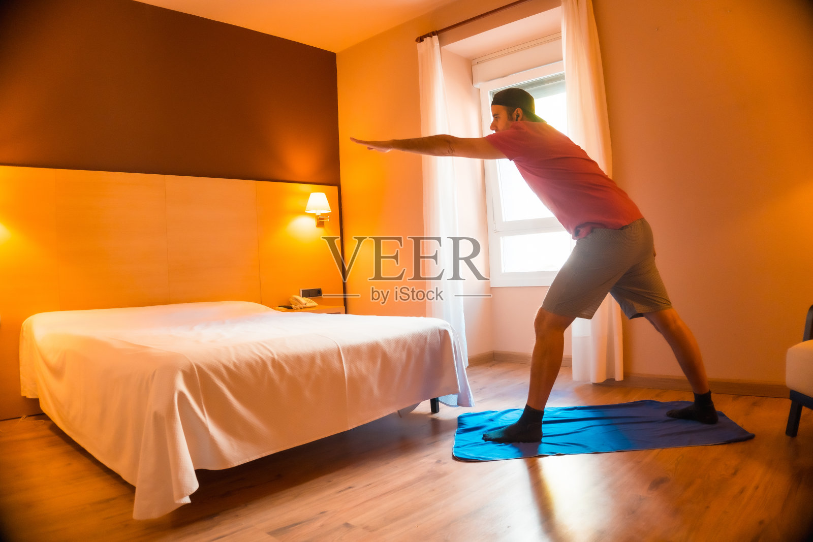 一名年轻白人男子在隔离新冠肺炎大流行(covid-19)的情况下在家运动。执行延伸照片摄影图片