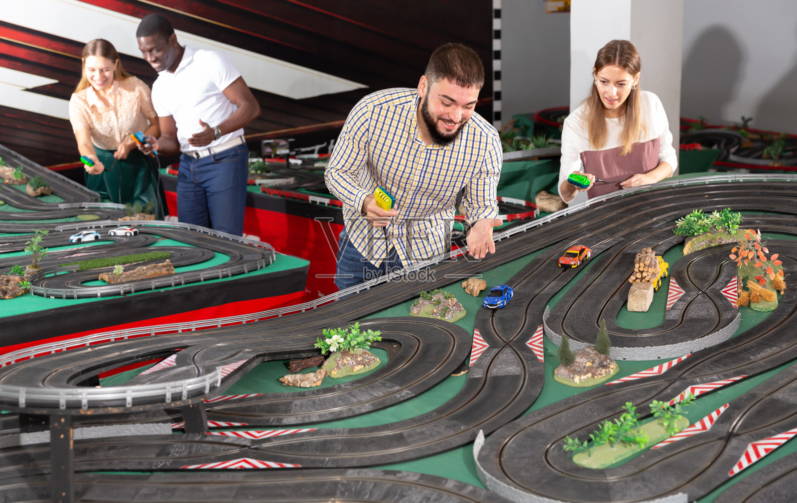 两队夫妇玩老虎机赛车游戏照片摄影图片