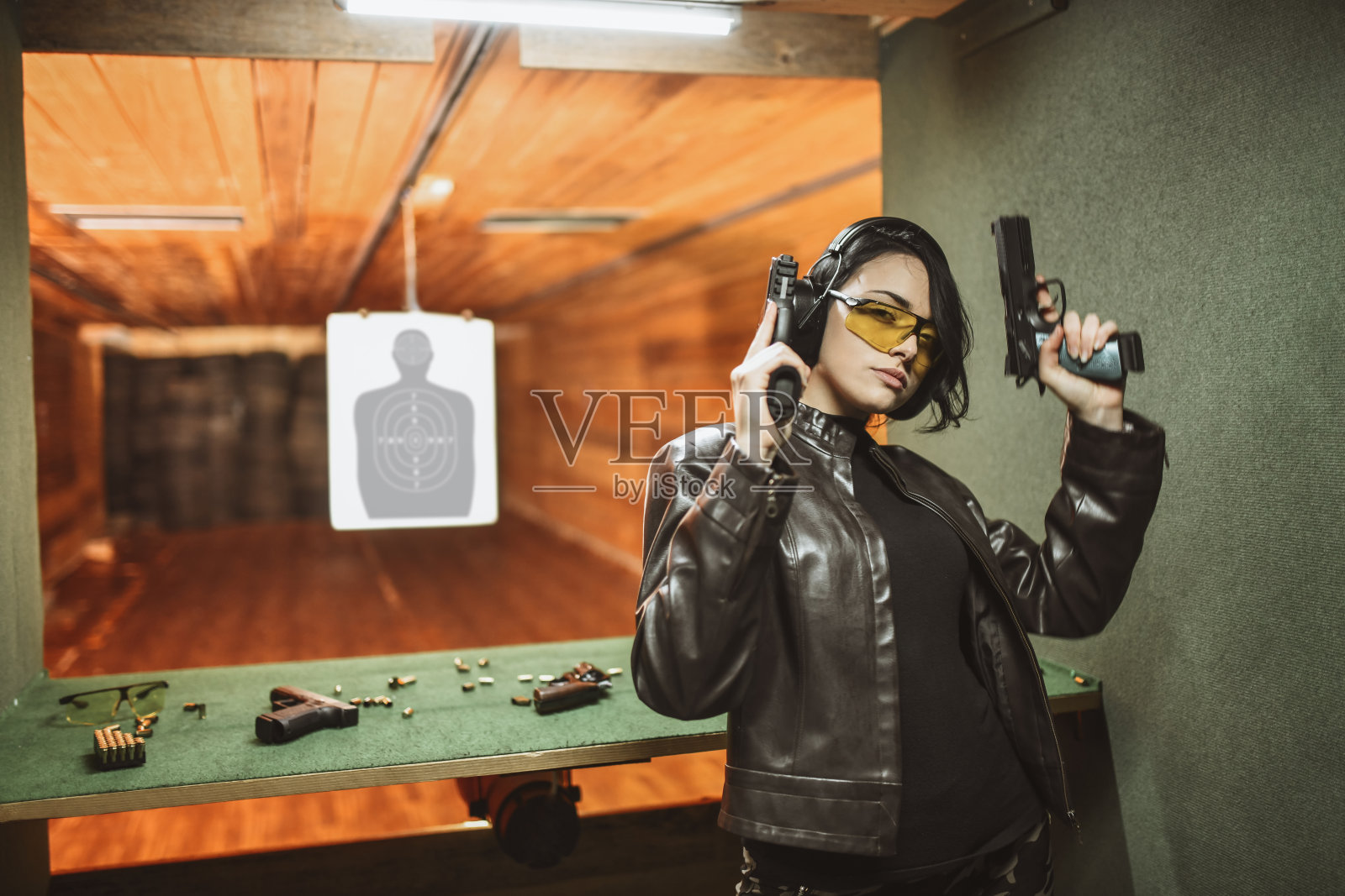可爱的女性和她最喜欢的两把枪在靶场照片摄影图片