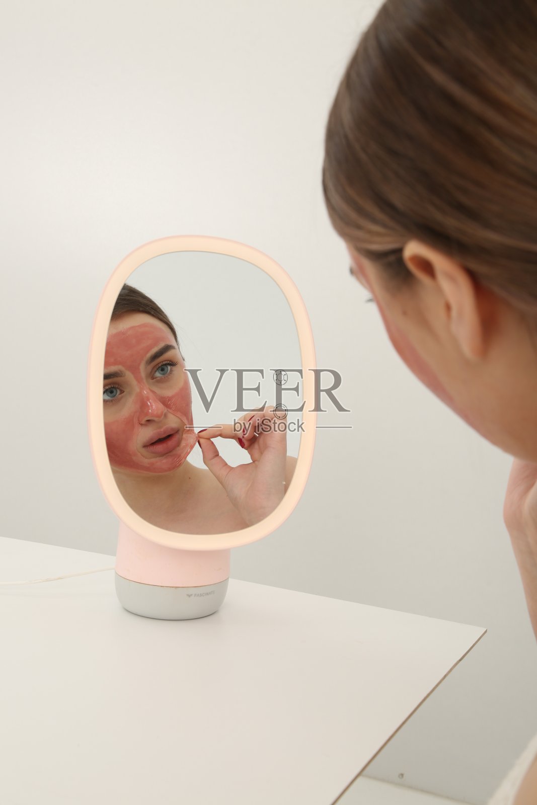 年轻美丽的女孩在皮肤上敷面膜。照片摄影图片