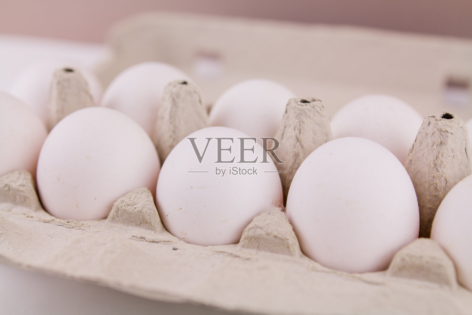 新鲜的生鸡蛋在纸板托盘上，在白色的背景照片摄影图片