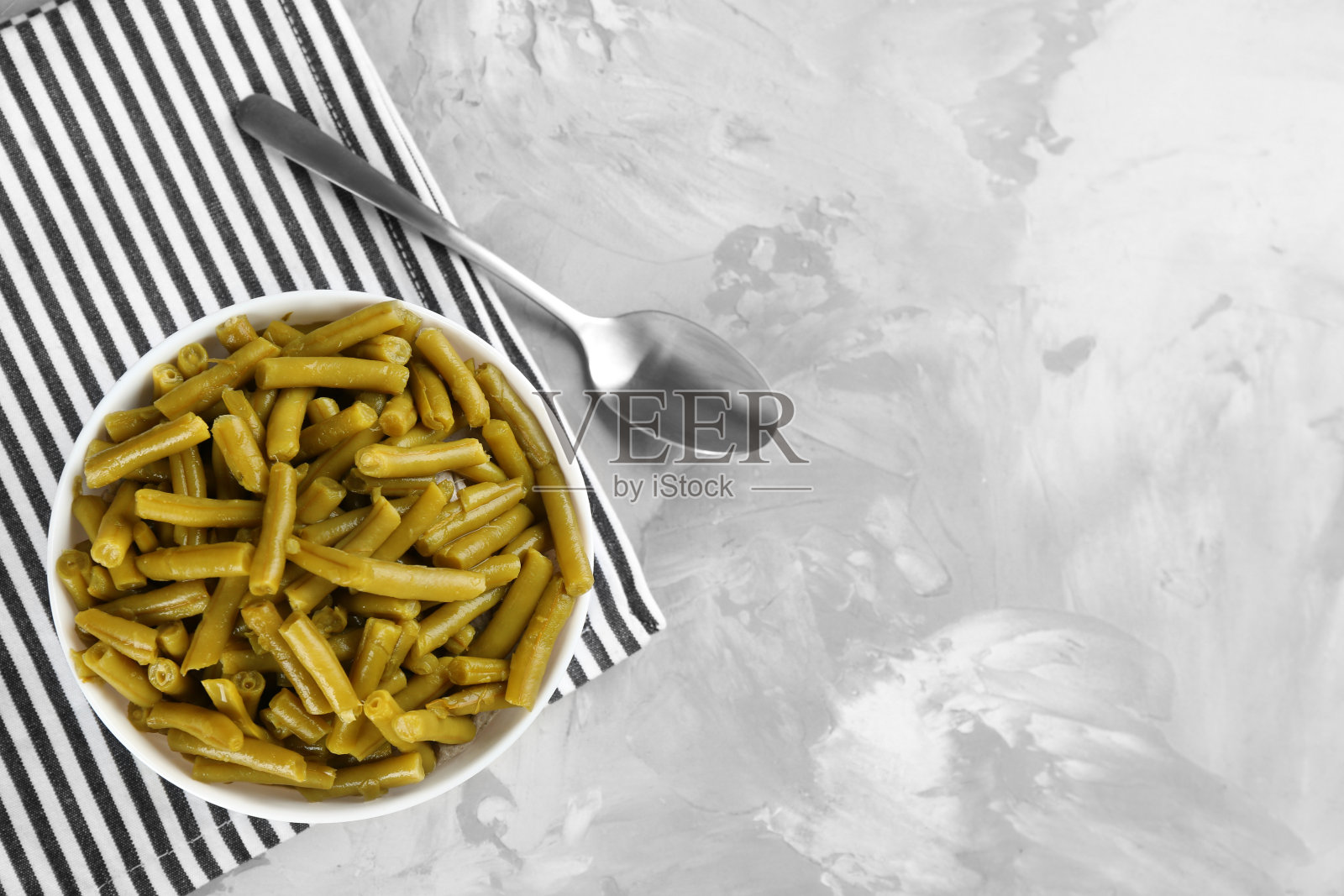 灰色的桌子上平放着青豆罐头。空间的文本照片摄影图片