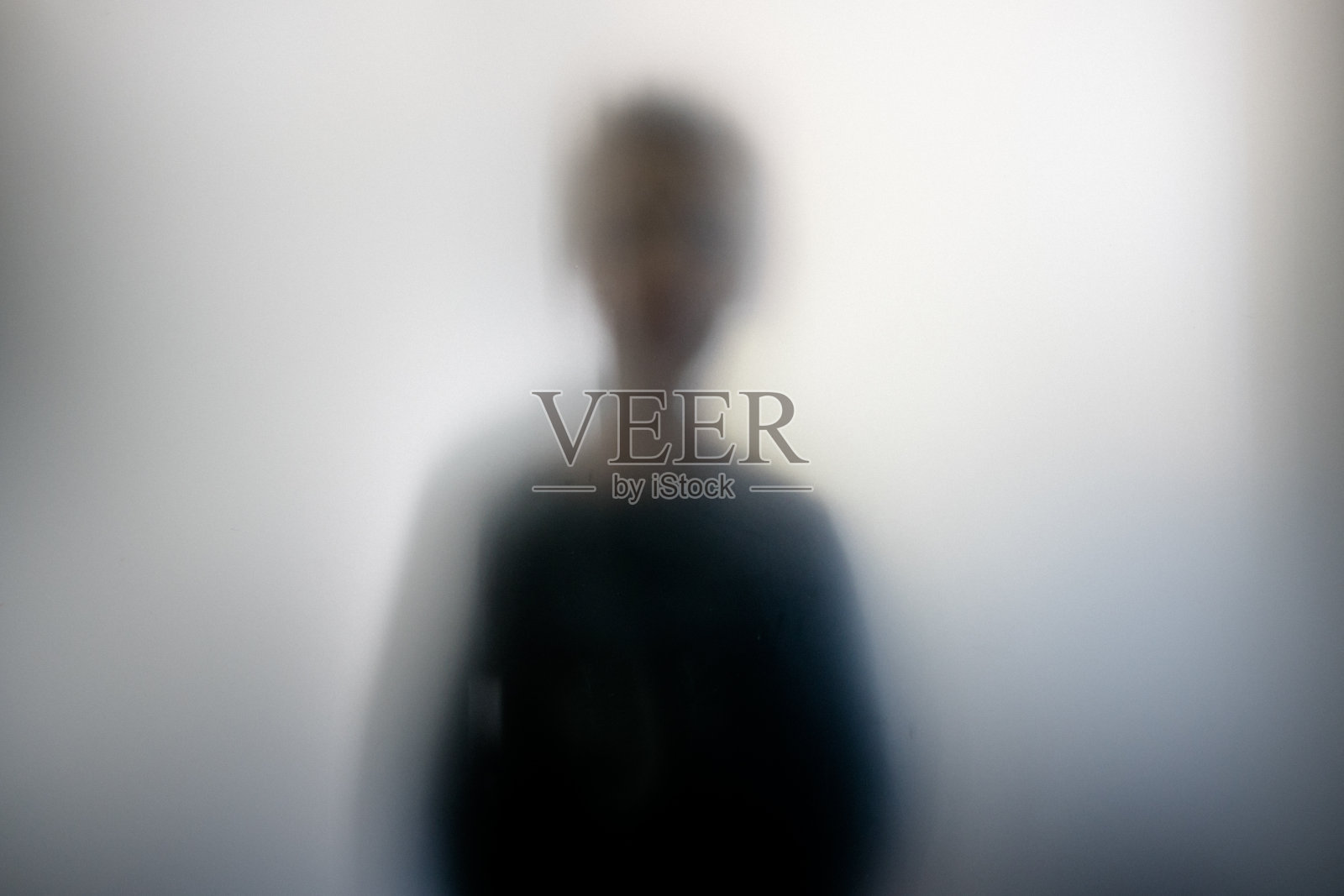 孩子站在磨砂玻璃后面照片摄影图片