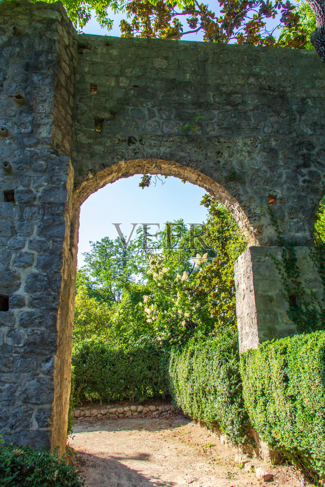 克罗地亚Trsteno Arboretum的绿色自然之间的石头弧形在夏季阳光明媚的一天。照片摄影图片