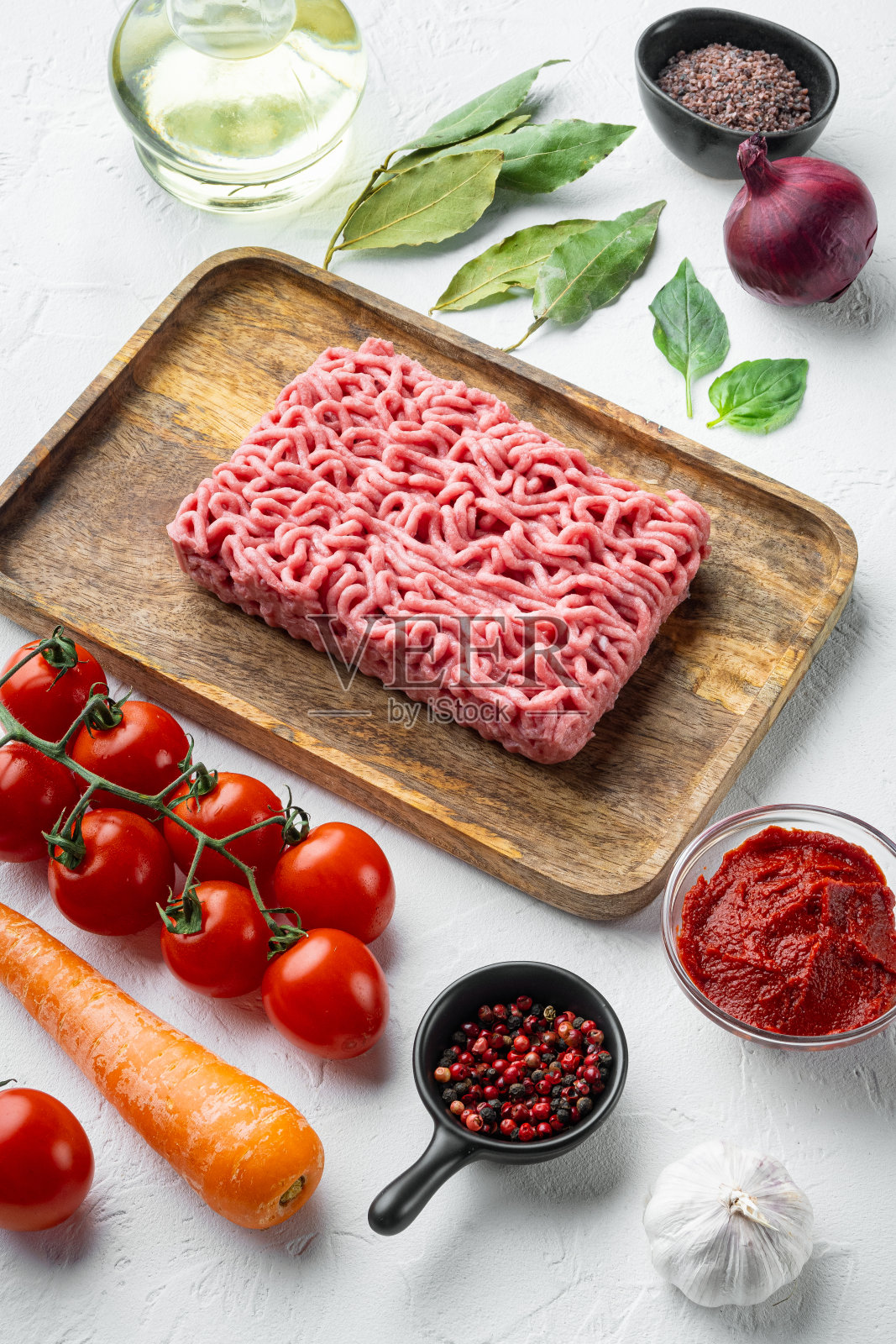 经典意大利肉酱配料，碎肉，西红柿和香草，木盘上，白石背景照片摄影图片