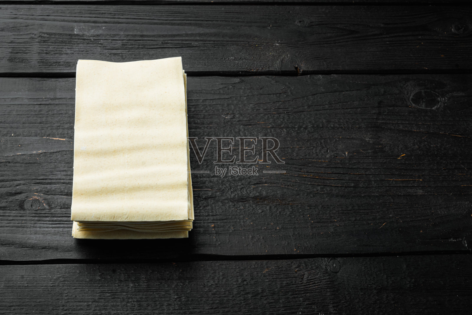 有机千层面意面片，在黑色木制桌子的背景，与文本复制空间照片摄影图片