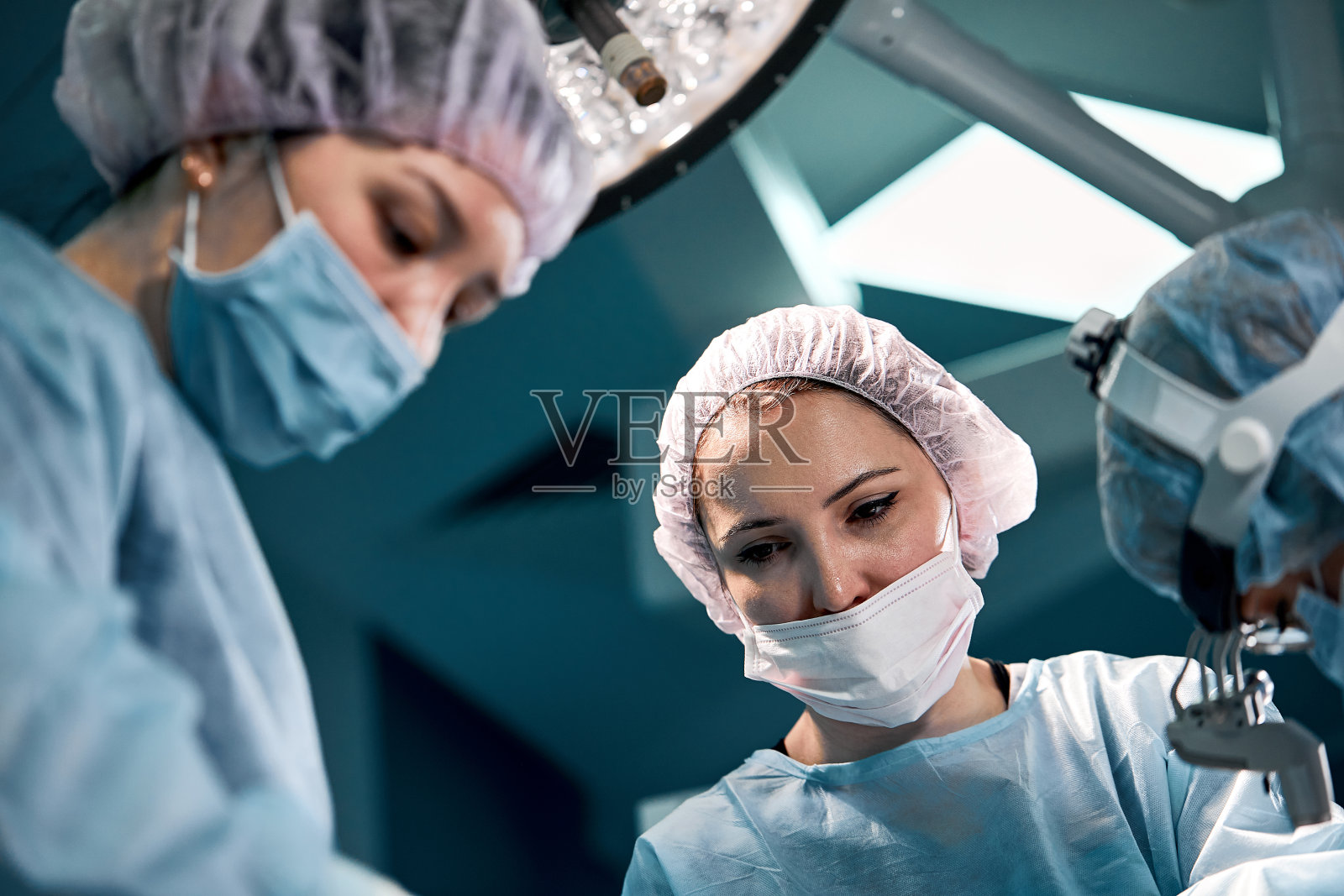 一组外科医生正在为生命而战，为真正的手术而战，为真正的情感而战。重症监护小组正在与病人的生命作斗争。拯救生命，奋斗生命照片摄影图片