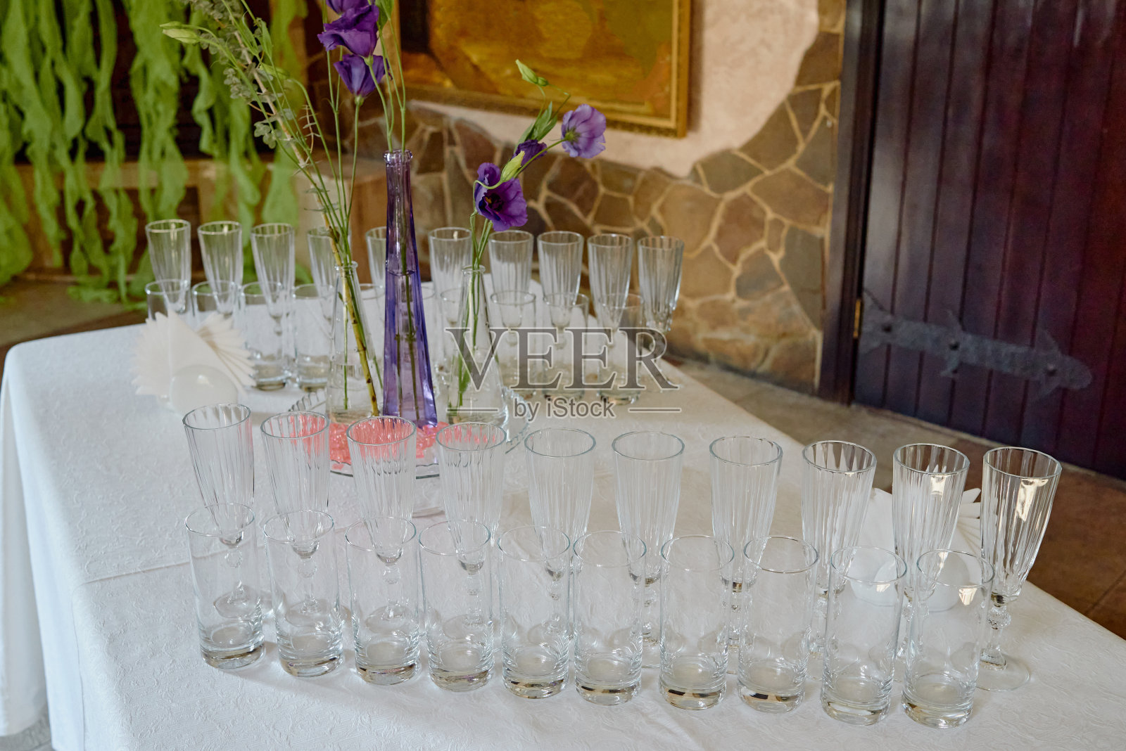 餐厅、复印区餐桌上闪闪发光的玻璃器皿和鲜花。准备好庆祝的水晶酒杯。豪华婚宴上的酒杯照片摄影图片