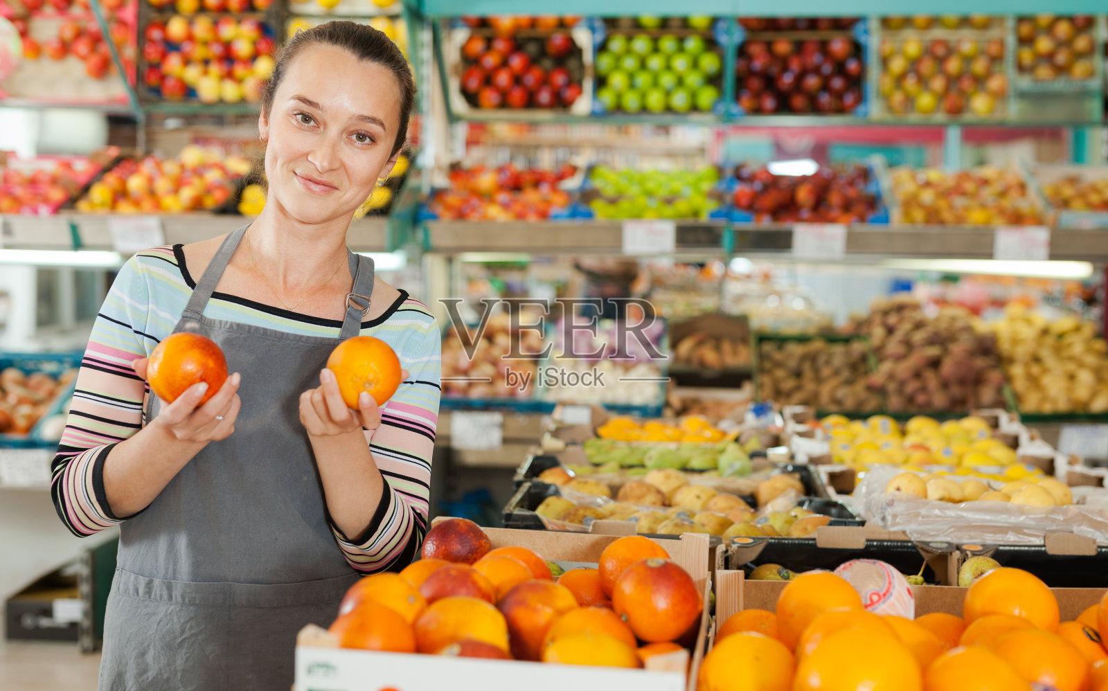 在水果部工作的女售货员照片摄影图片
