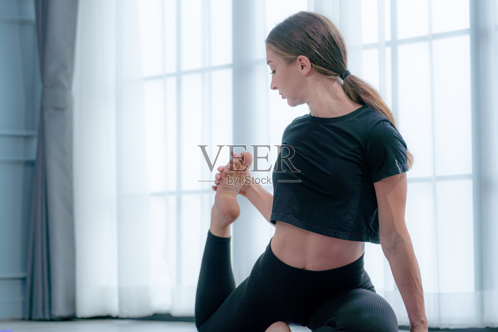 美丽健康的女人练习瑜伽。年轻女性与瘦削套房休息和谈话，而锻炼后一起健身课。概念健康生活方式在家锻炼。照片摄影图片