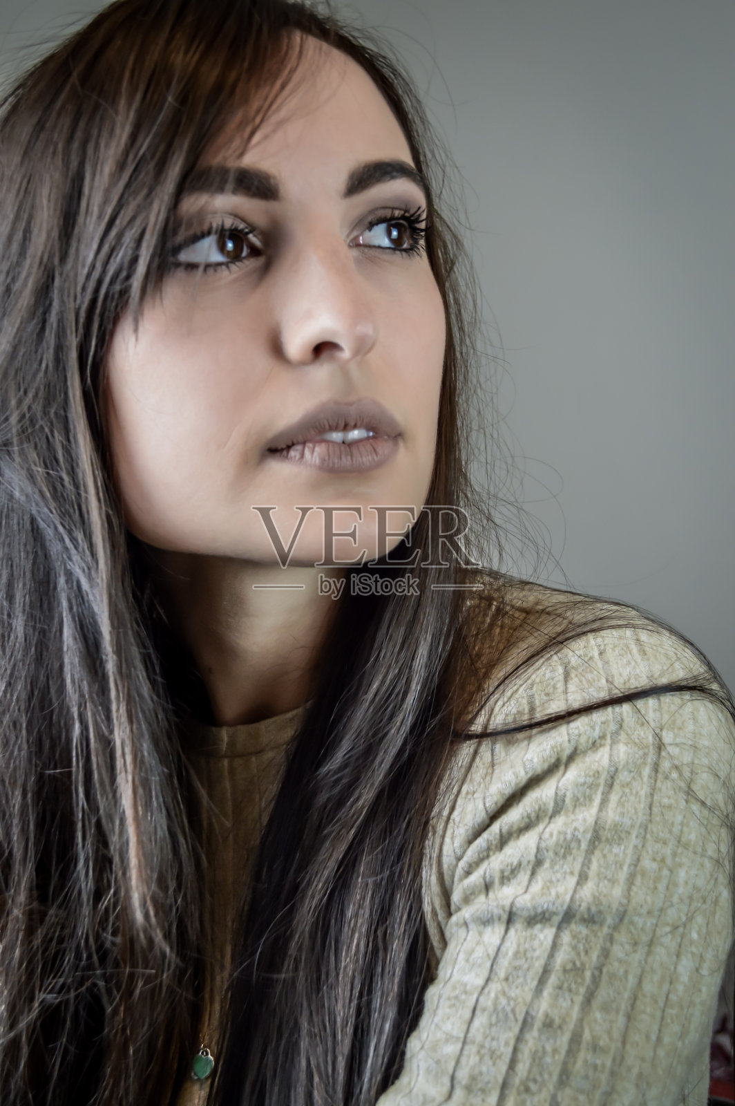 一个美丽的年轻女子的肖像与长棕色头发与梦幻的目光远离照片摄影图片
