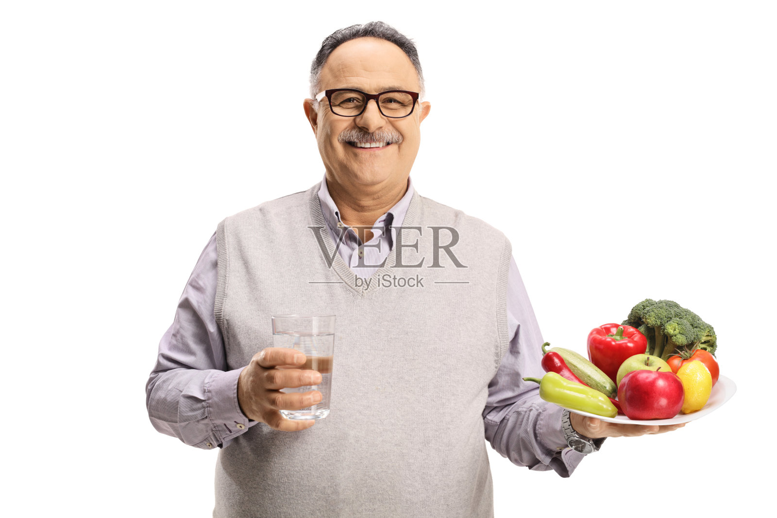 微笑的成熟男人拿着一杯水和一盘水果蔬菜照片摄影图片
