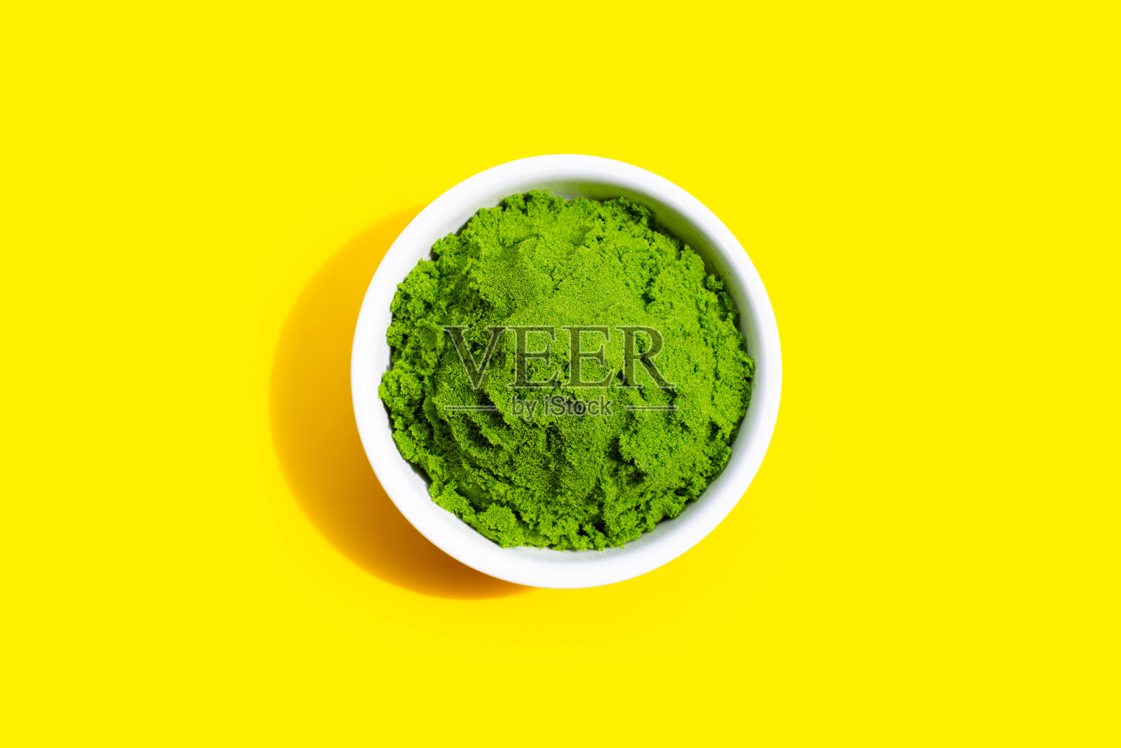 灰狼或水餐在白色的碗黄色的背景。照片摄影图片