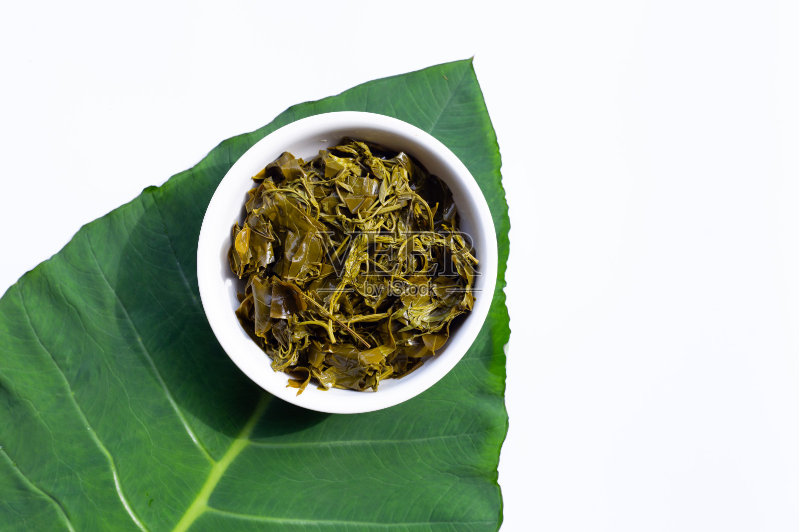番泻叶在白碗上煮熟，盖在芋头叶上照片摄影图片