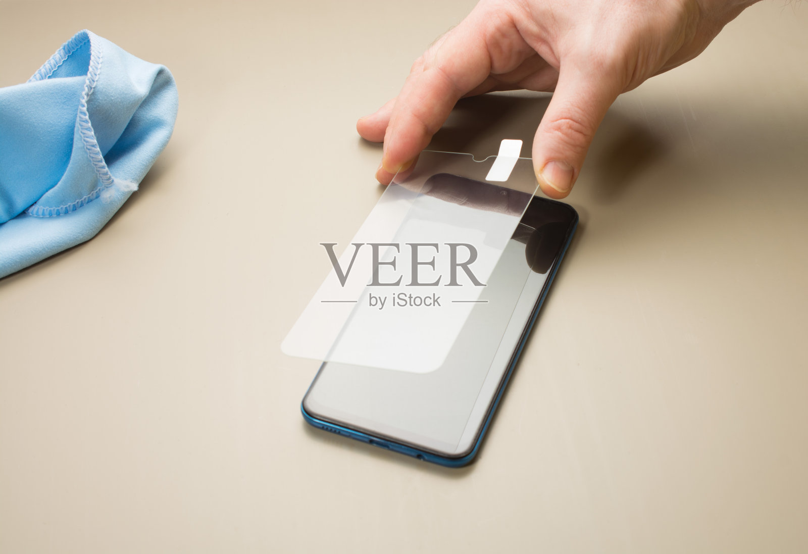 人们在智能手机上放上保护玻璃或薄膜照片摄影图片