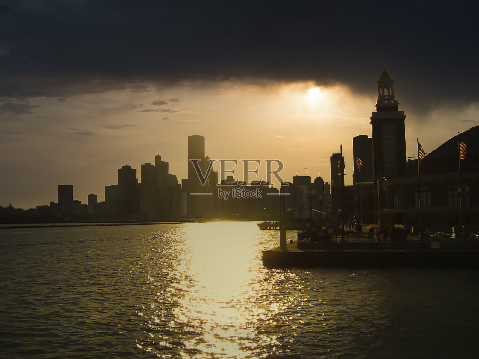 夏日的海湾日落，背后是摩天大楼照片摄影图片