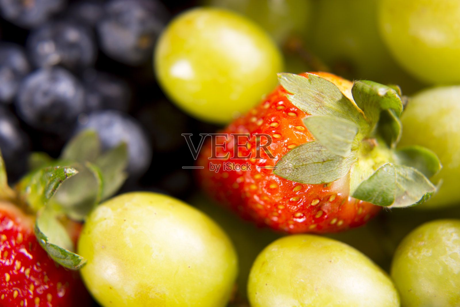 水果背景-新鲜果汁草莓，蓝莓和葡萄。照片摄影图片