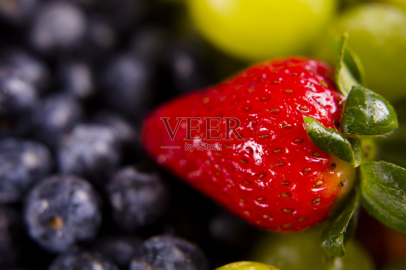 水果背景-新鲜果汁草莓，蓝莓和葡萄。照片摄影图片