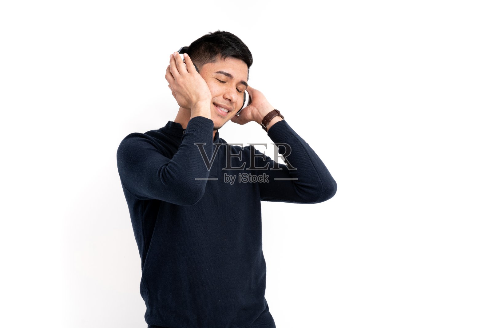 一个戴着耳机听白色背景音乐的拉丁人照片摄影图片