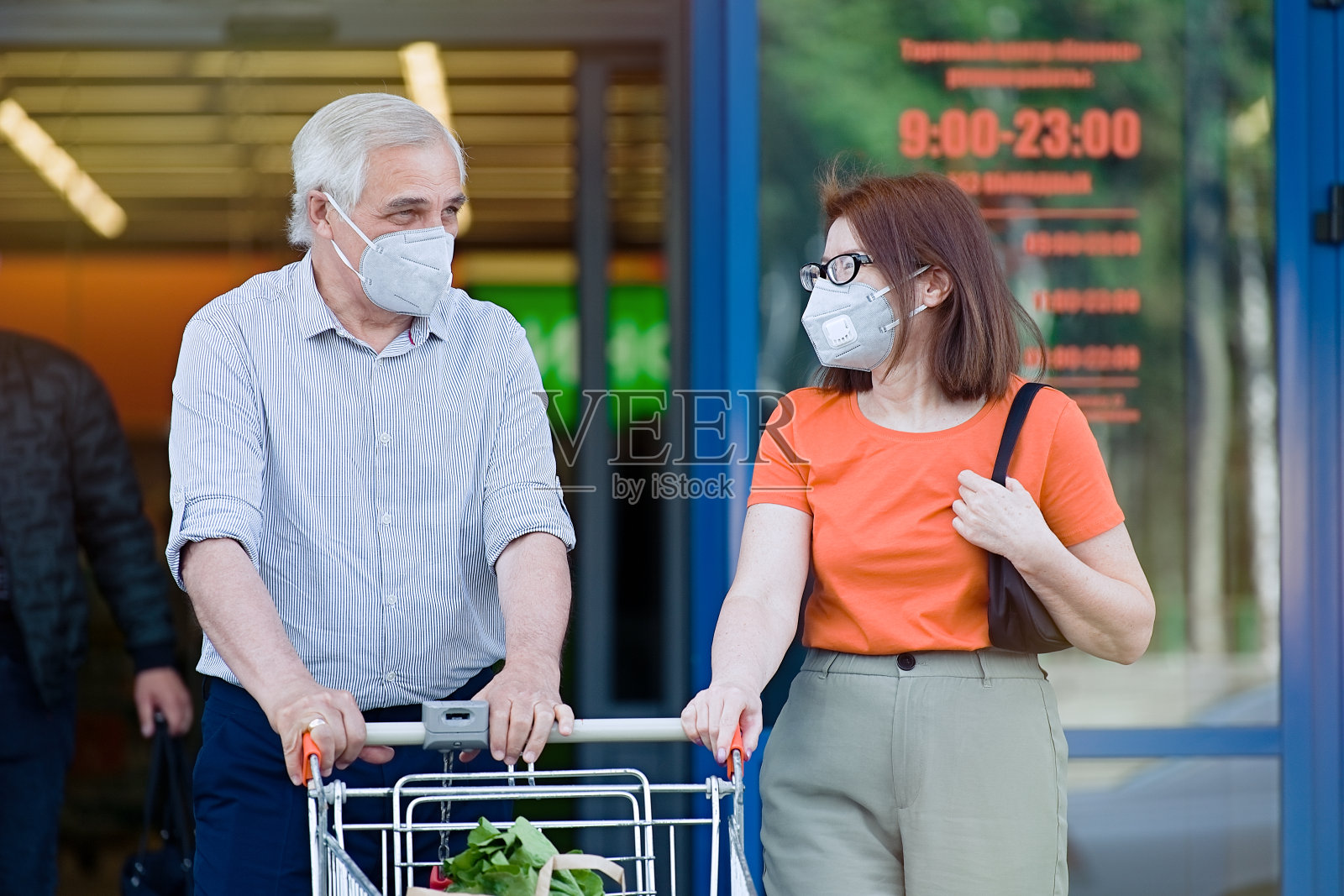 一对戴着口罩的老年夫妇从超市出来照片摄影图片