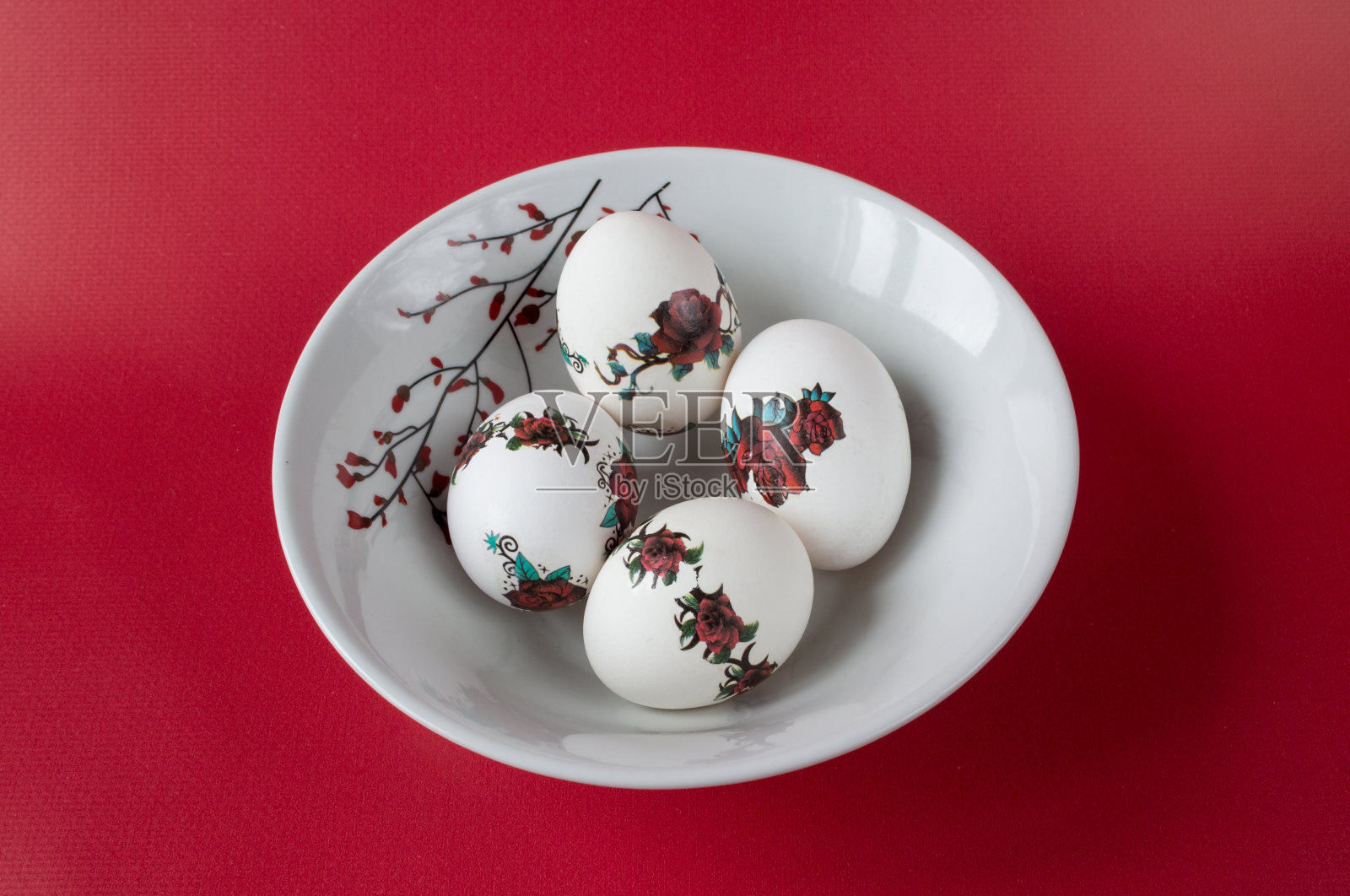 在红色背景的盘子里装复活节彩蛋。照片摄影图片