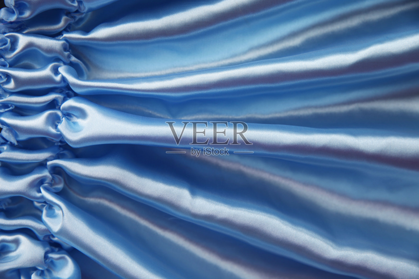 蓝色丝织的波浪褶皱，抽象的背景照片摄影图片