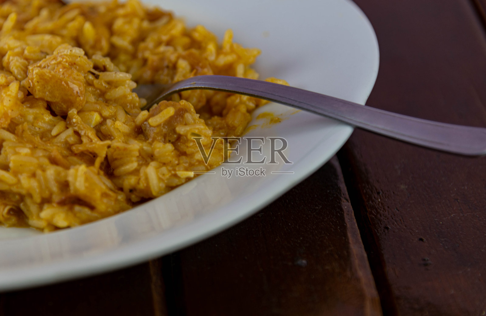 自制的鸡肉调味饭放在白色的盘子里。用瓷器盛的意大利米饭。照片摄影图片