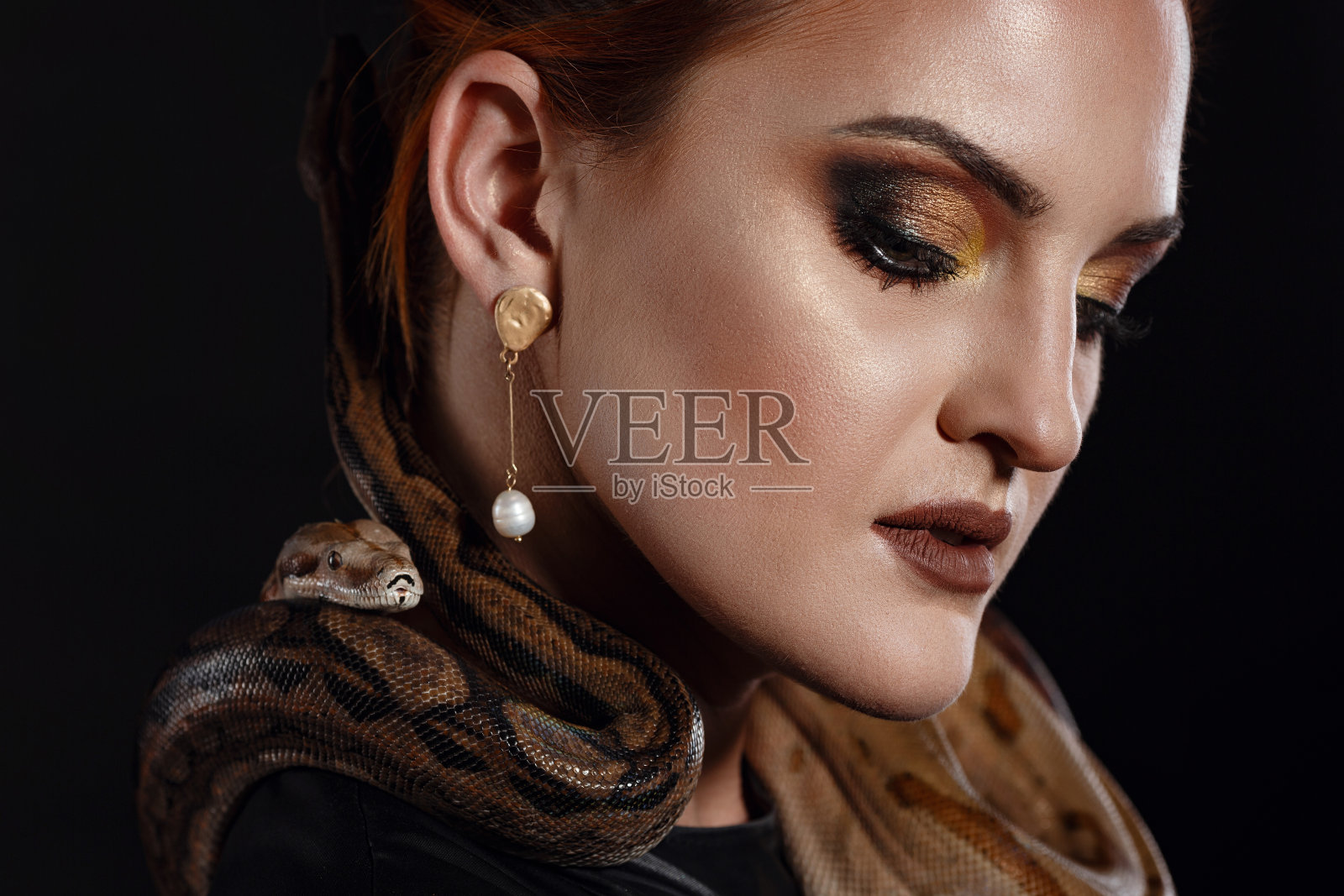 近距离肖像性感的女人与蛇在乳胶装照片摄影图片