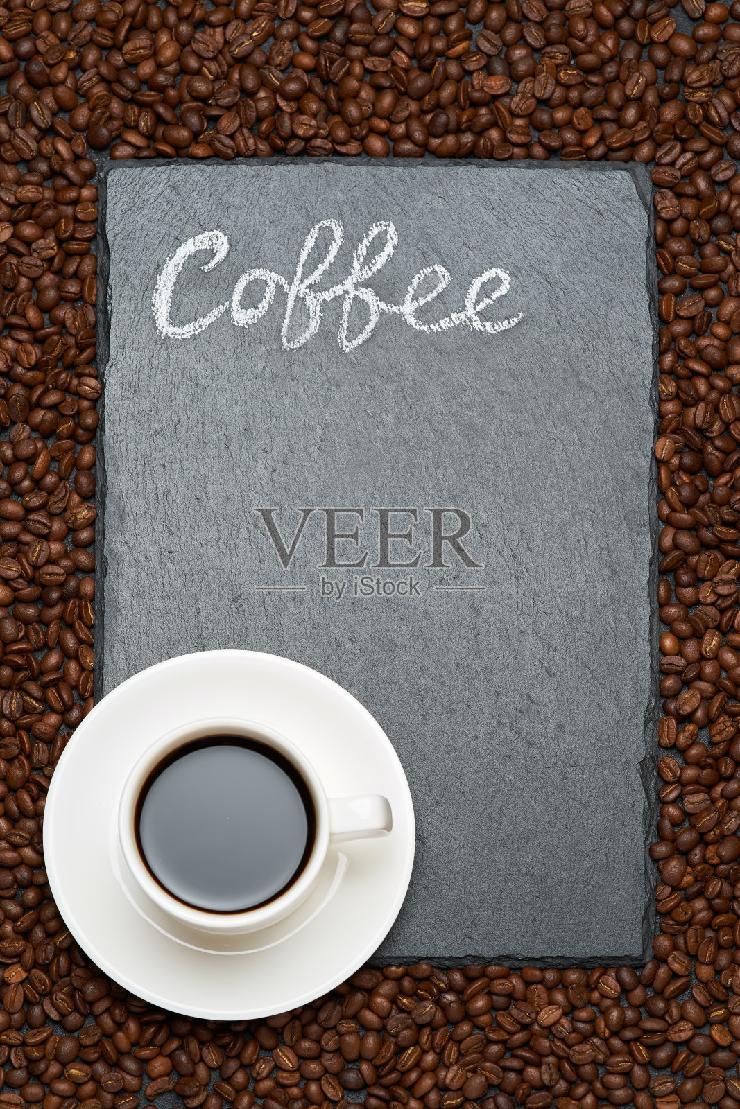 背景或纹理的烤棕色咖啡豆和石头的服务板上有粉笔手写的标志照片摄影图片