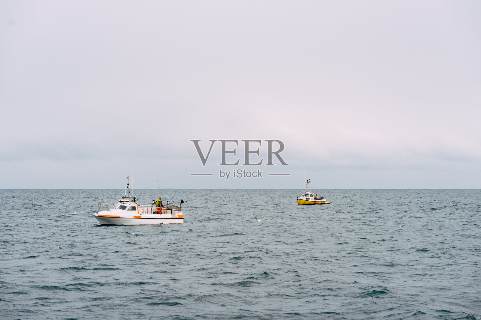 白色的渔船漂浮在冰岛的沿海水域照片摄影图片