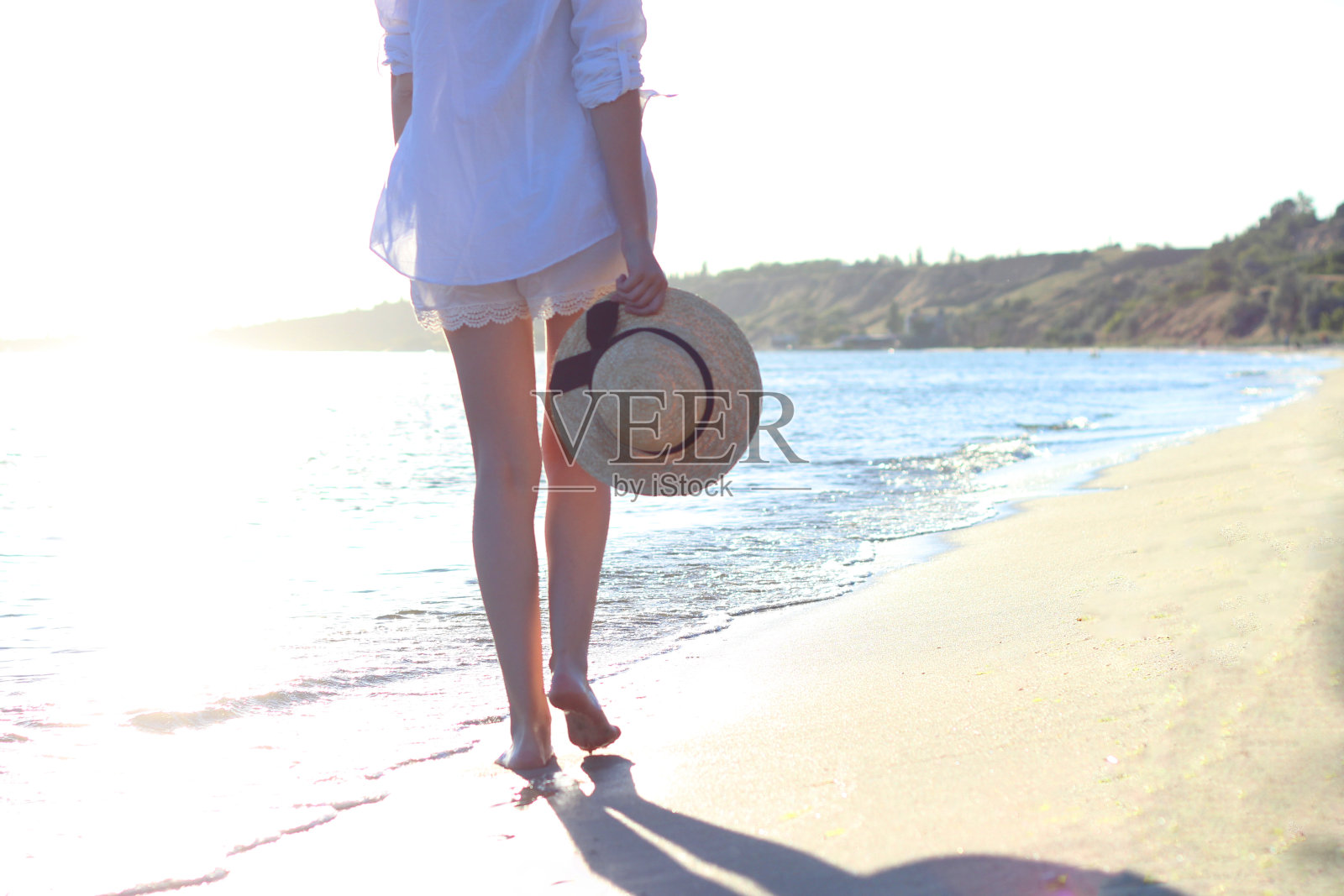 那个女孩正在海滩上散步照片摄影图片