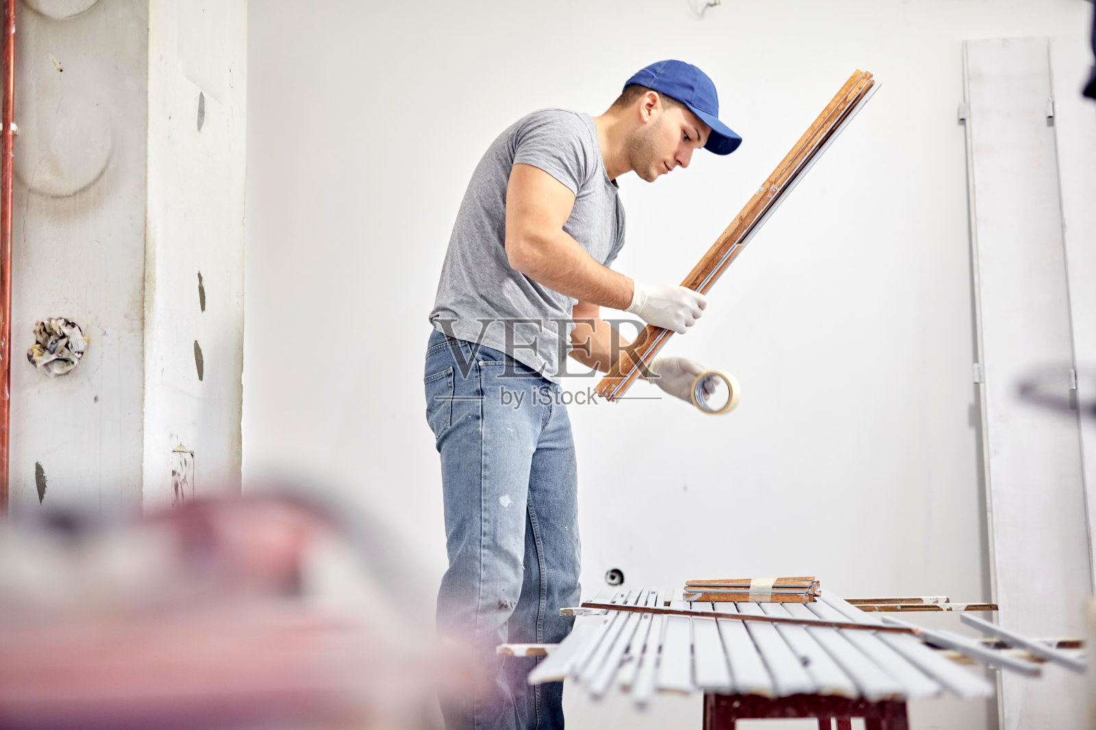 年轻的成年人在DIY预算装修他的新家公寓。照片摄影图片