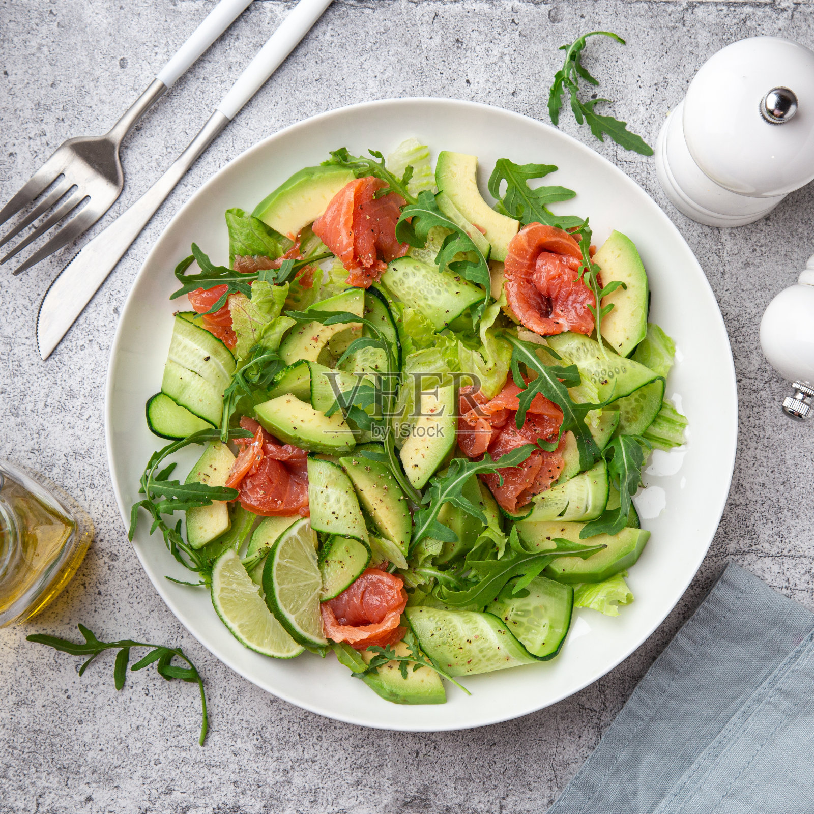 白盘子里有鳄梨、烟熏鲑鱼和黄瓜沙拉照片摄影图片