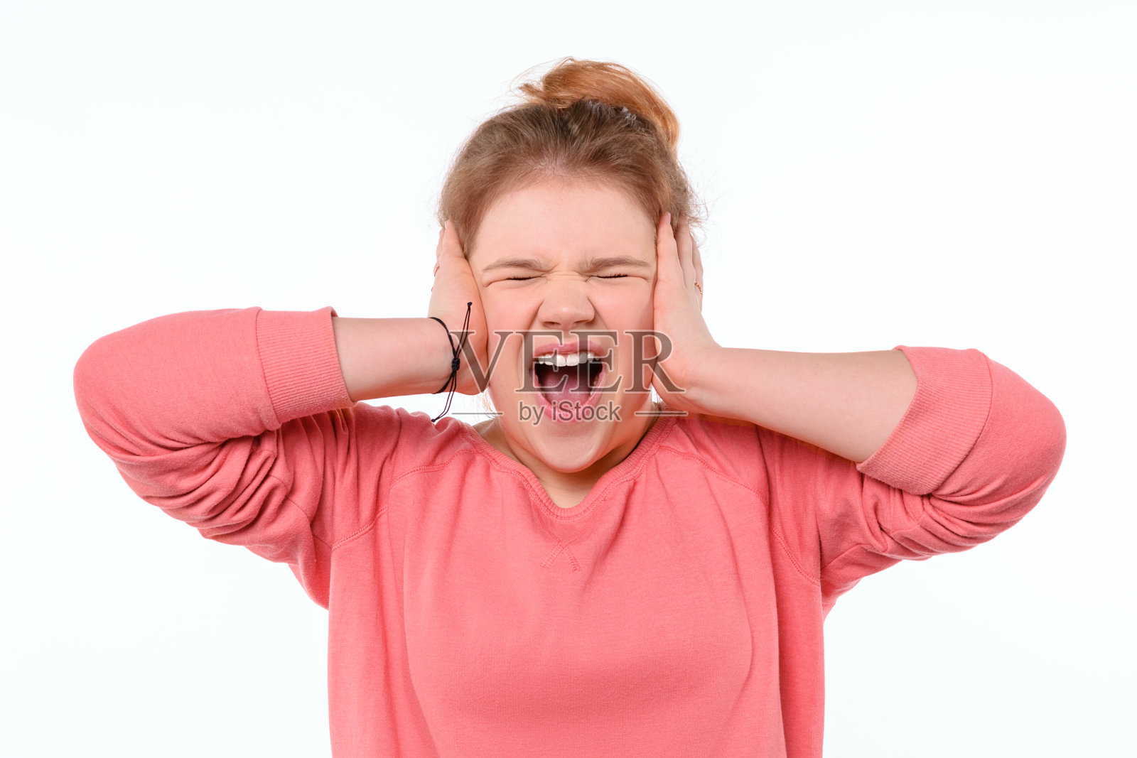 年轻女孩的肖像在恐慌中大叫和抓住她的头在恐惧或挫折。工作室拍摄，白色背景照片摄影图片