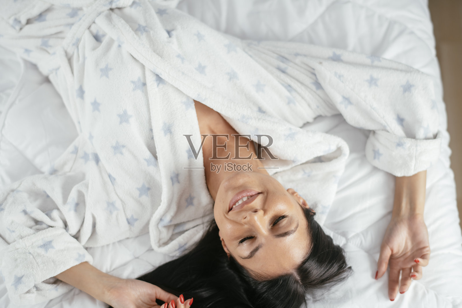 美丽的年轻女子在床上放松早上。库存图片照片摄影图片