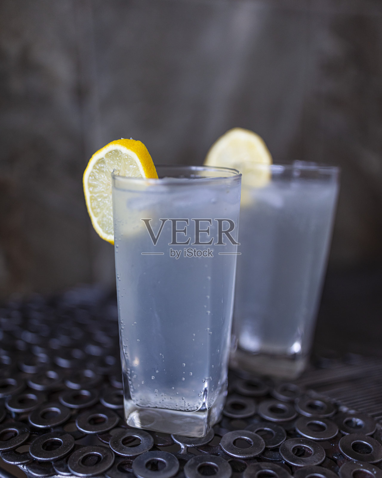 特写两杯杜松子酒加冰块和一片柠檬。照片摄影图片