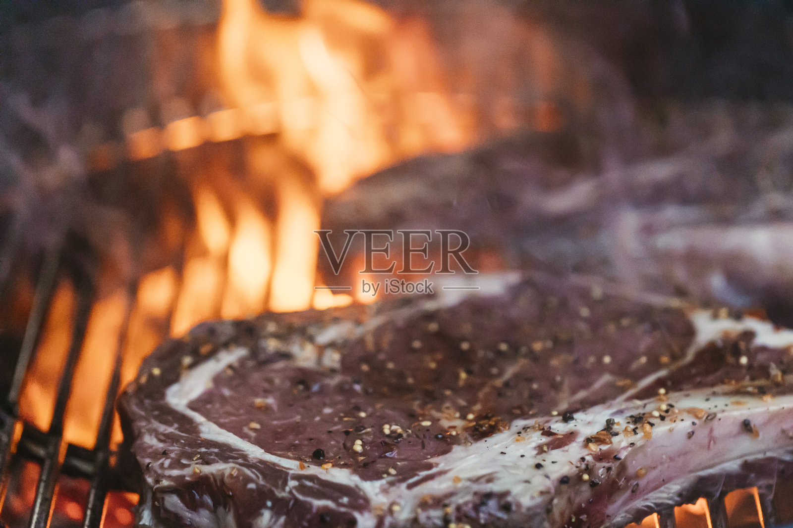 在木炭烧烤架上烹饪肋排的特写。照片摄影图片