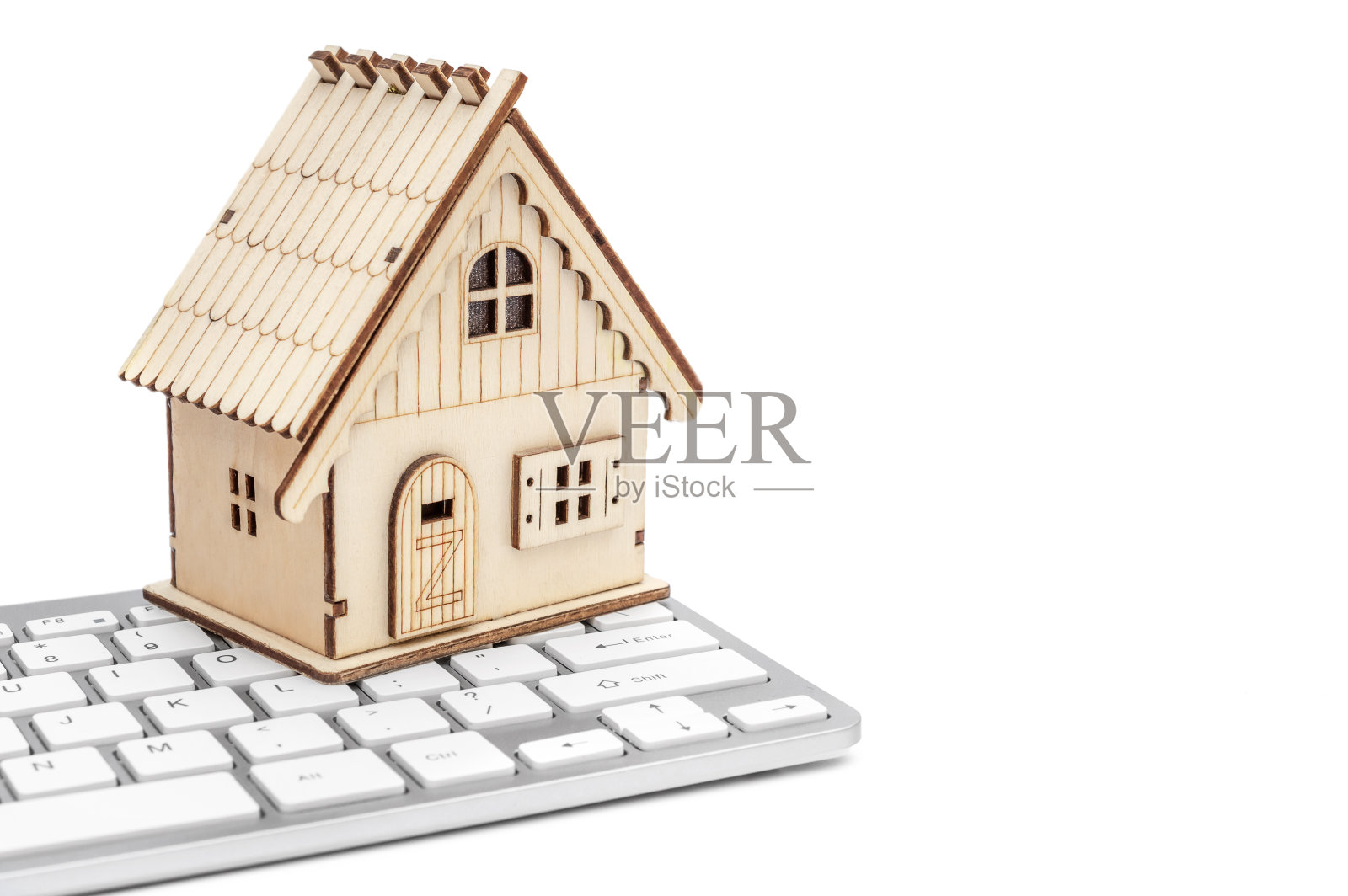 白色背景上电脑键盘的房子模型。照片摄影图片