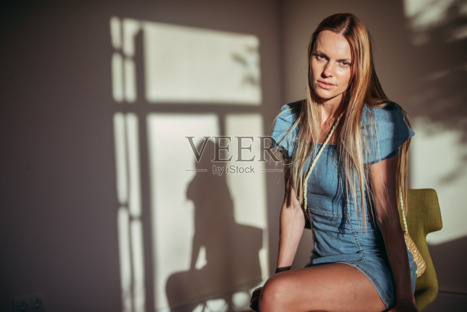 的情绪。一个坐在椅子上害羞的女人的肖像。照片摄影图片