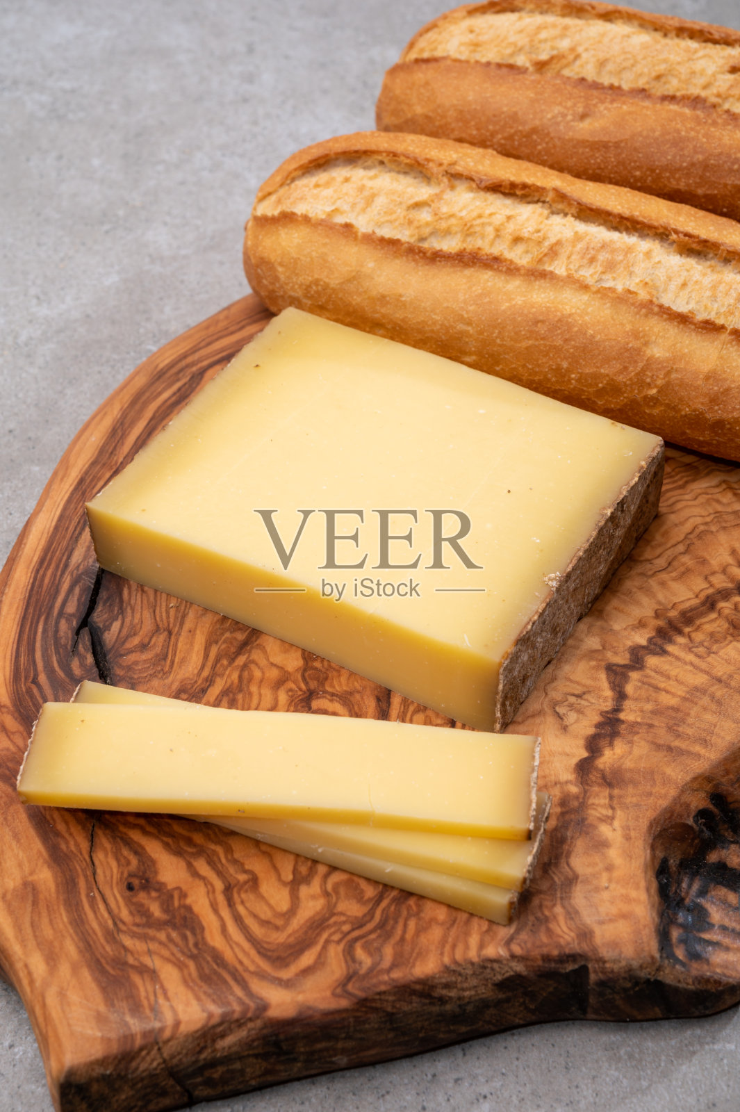 法国食品——用法国弗朗契地区的牛奶制成的一块奶酪和新鲜烘焙的长棍面包。照片摄影图片