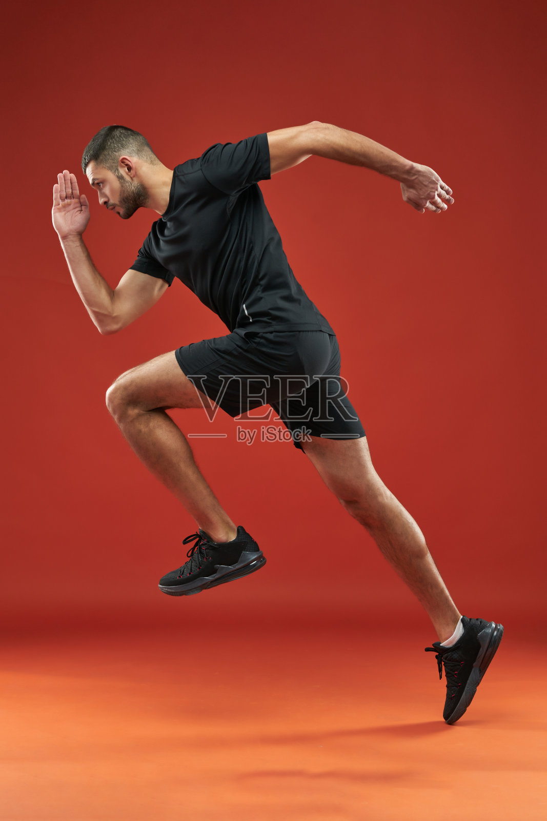 强壮的运动员穿着黑衬衫和短裤在体育俱乐部锻炼照片摄影图片