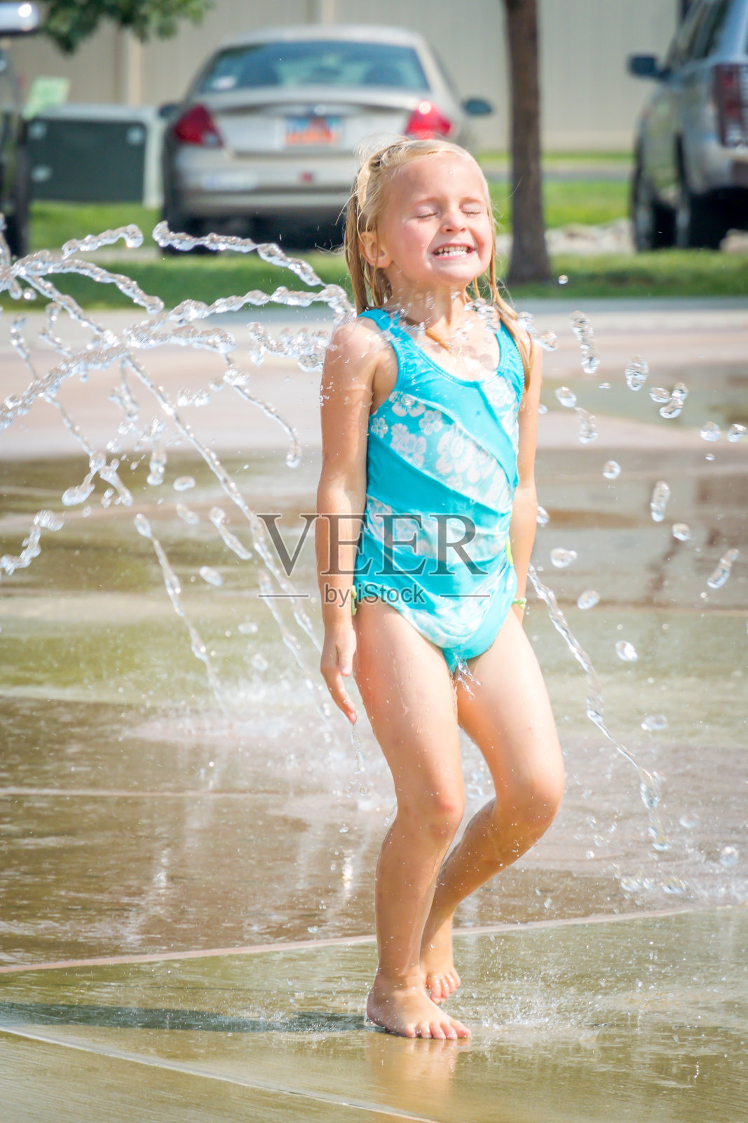 可爱的小女孩在水里玩飞溅垫照片摄影图片