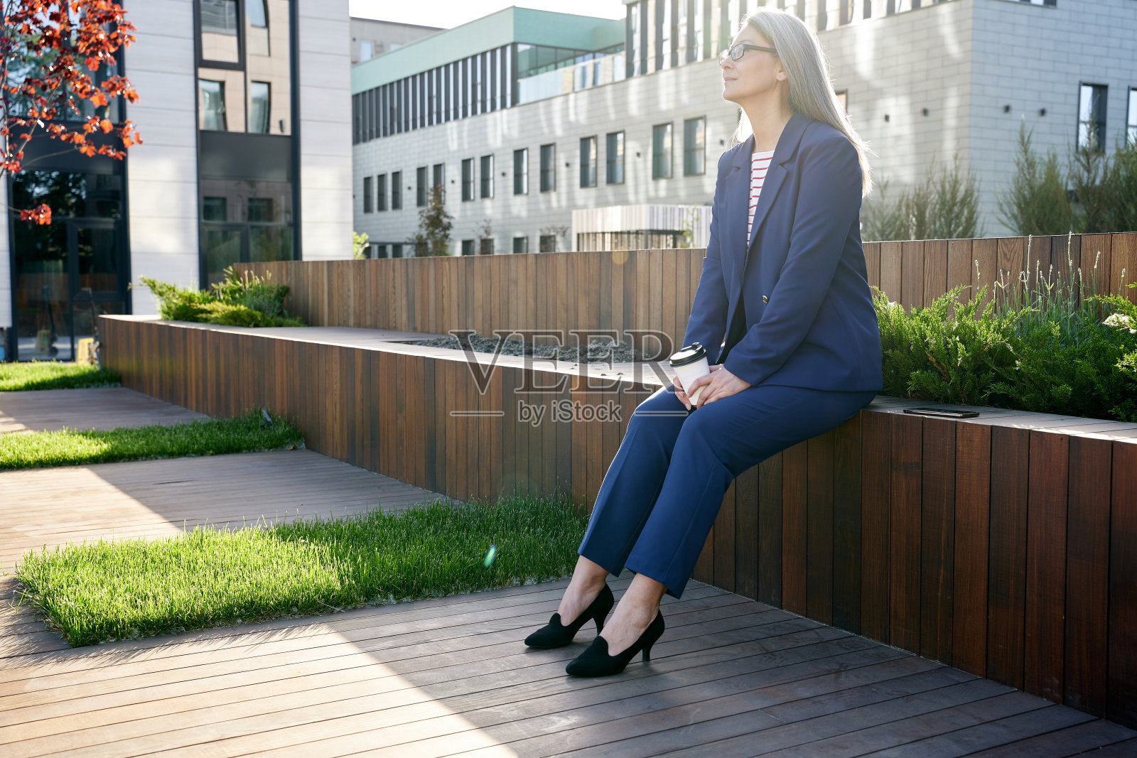 迷人的老女人穿着西装享受新鲜的空气和阳光照片摄影图片