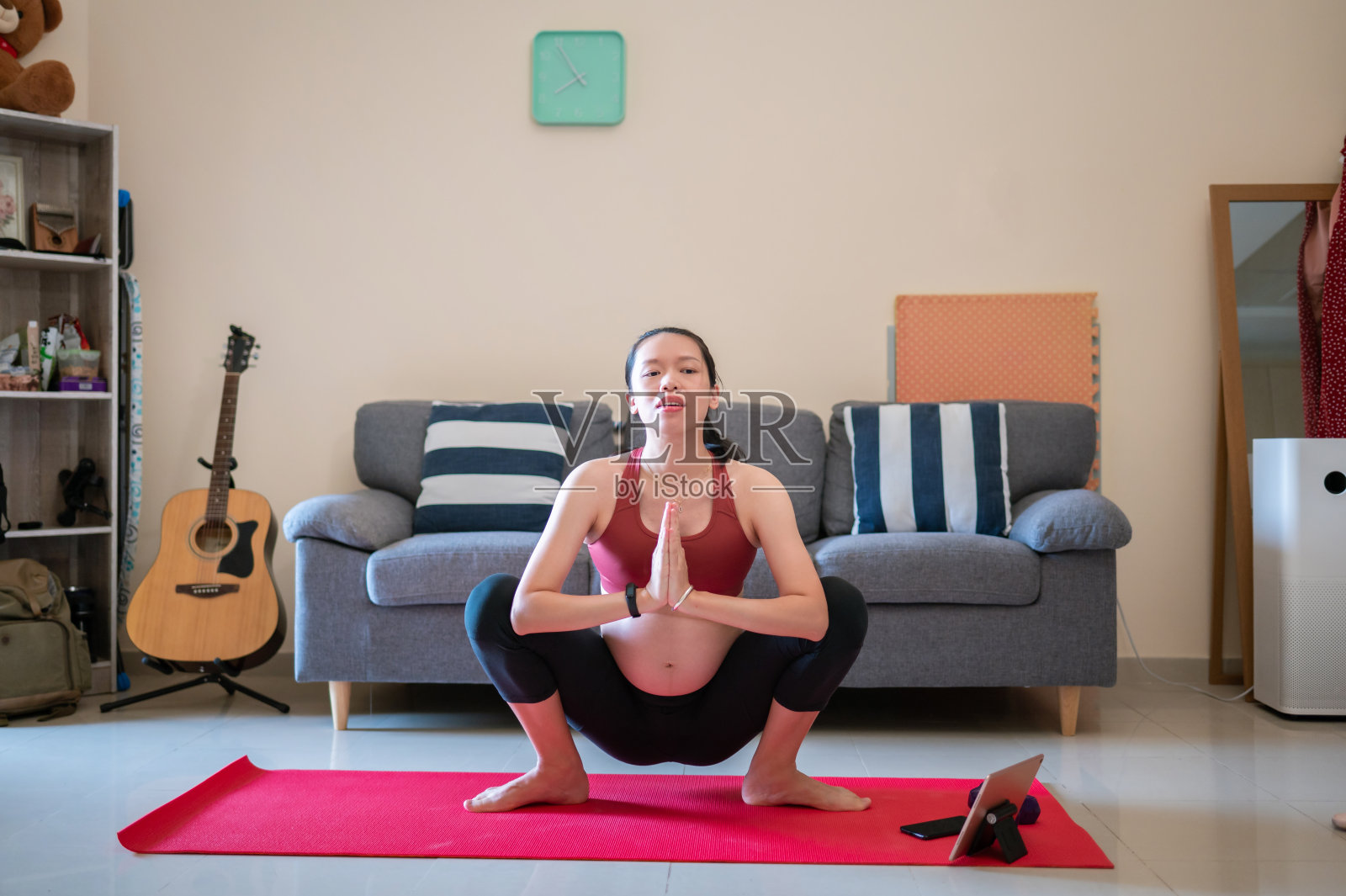 孕妇在家里的瑜伽垫上锻炼照片摄影图片