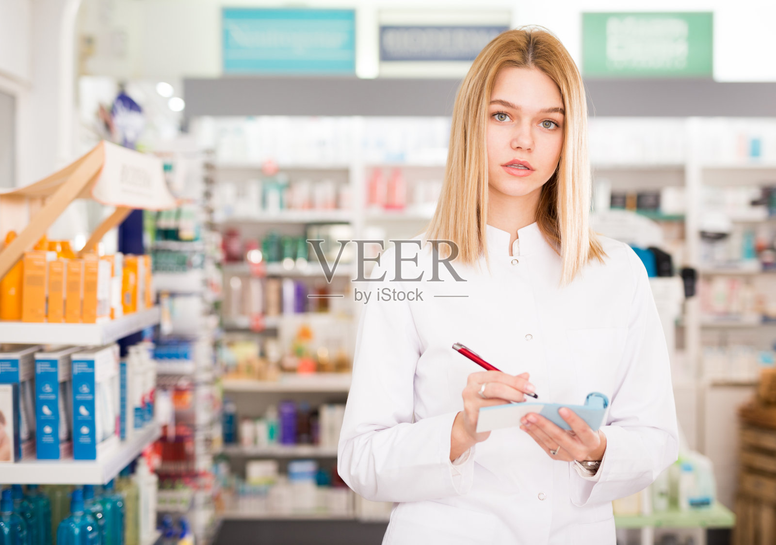 药剂师正在记下药房里的药品种类照片摄影图片