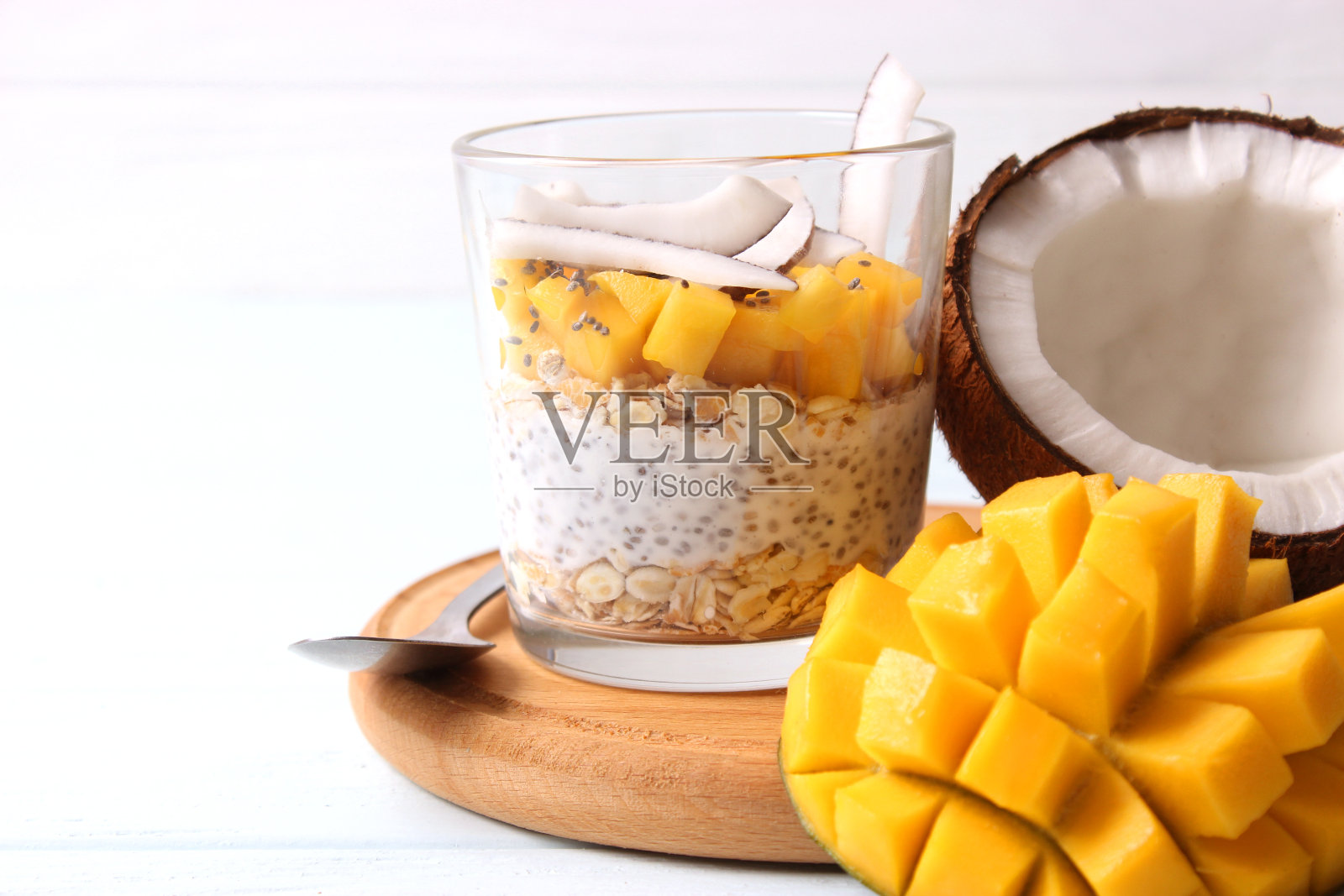 加芒果，格兰诺拉麦片和蜂蜜的奇亚布丁。健康的甜点，适当的营养照片摄影图片